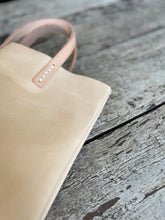 Load image into Gallery viewer, natural vegetable tanned leather bags small size, narrow-rectangular flat shape. two veg tan handles attached/sewn using belgian linen yarn. also made in distressed brown &amp; black leather and black &amp; tan suede. Retail price $195.
