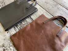 Load image into Gallery viewer, Black and brown leather bags small size, narrow-rectangular flat shape. two veg tan handles attached/sewn using belgian linen yarn. also made in natural vegetable tanned leather and black &amp; tan suede. Retail price $195.
